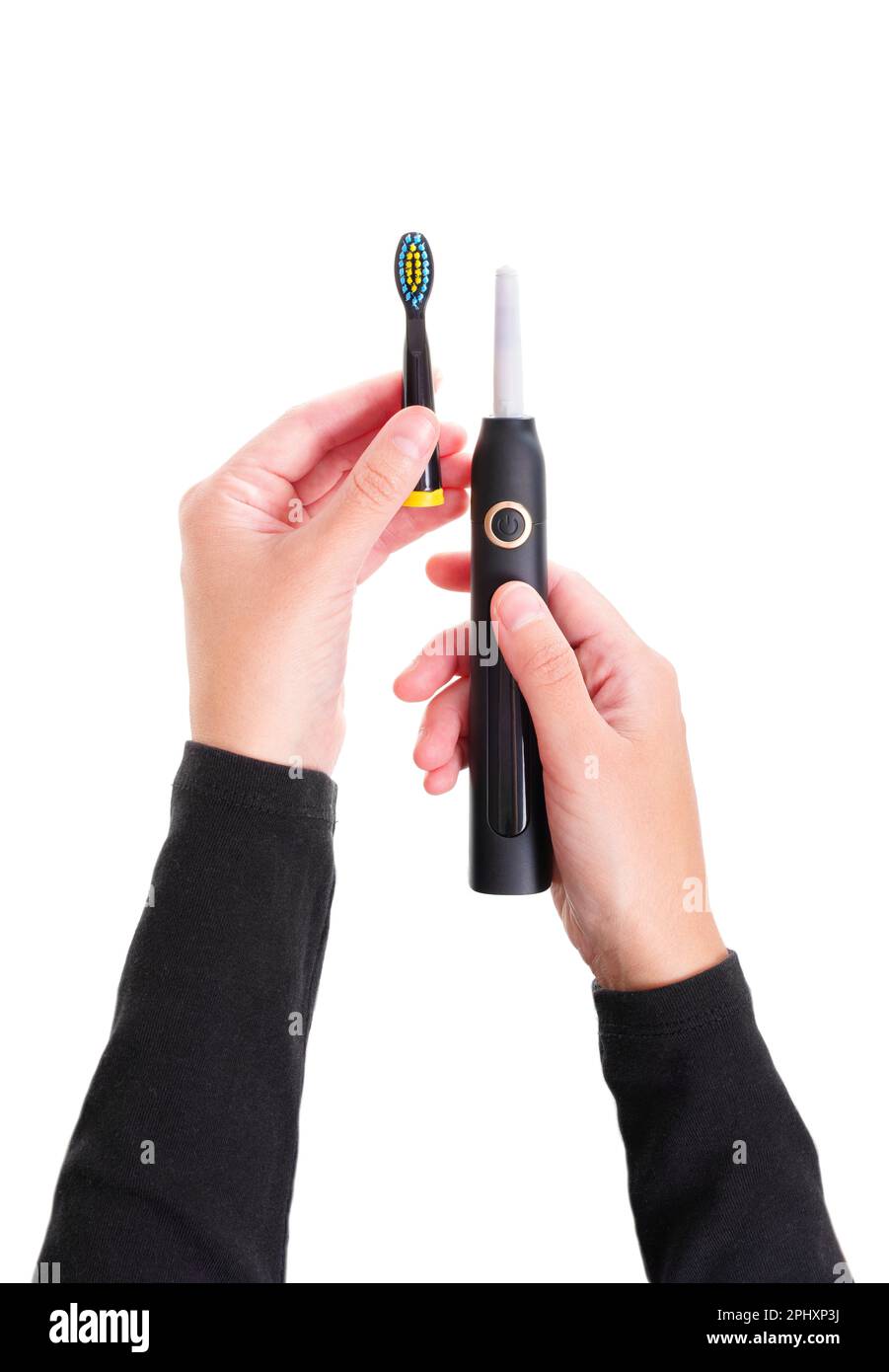 Vista ravvicinata delle mani di una persona che collega una testina a uno spazzolino elettrico. Concetto relativo alla cura dentale e all'igiene orale. Foto Stock