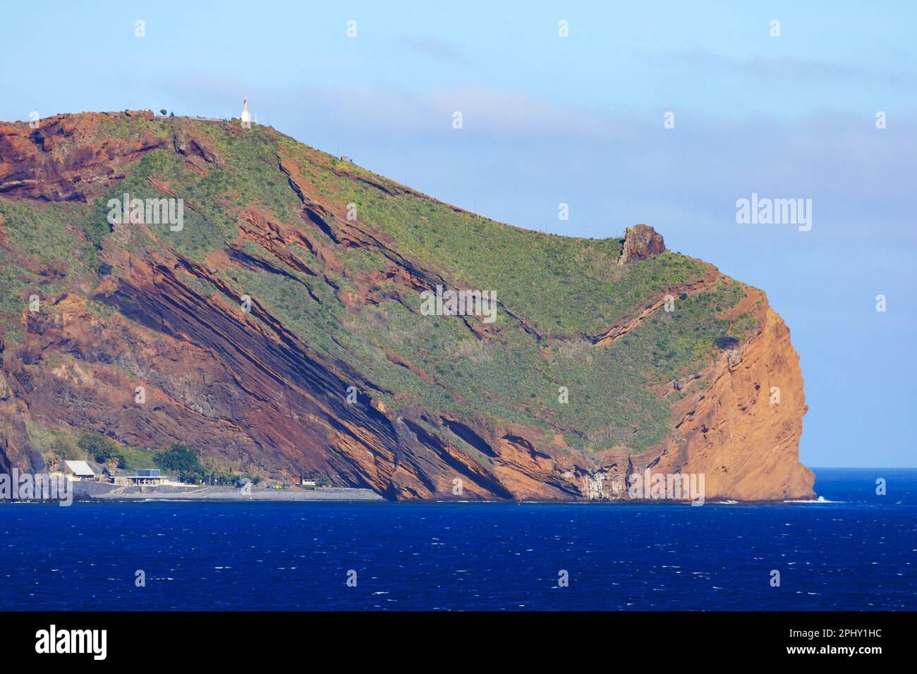 Il promontorio e le scogliere di da Ponta do Garajau con la statua di Cristo Rei vista dal mare. Funchal, Madeira, Portogallo Foto Stock