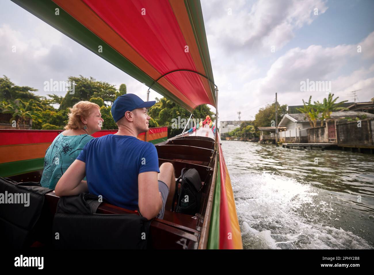 Donna anziana con il figlio adulto che si diverte a bordo di una barca tradizionale a Bangkok, Thailandia. Foto Stock