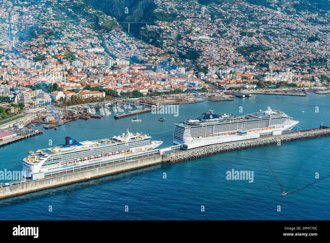 Una vista aerea del vivace porto e porto di Funchals, con una varietà di navi da crociera, veicoli e altri modi di trasporto in direzione del mare visibili. Foto Stock