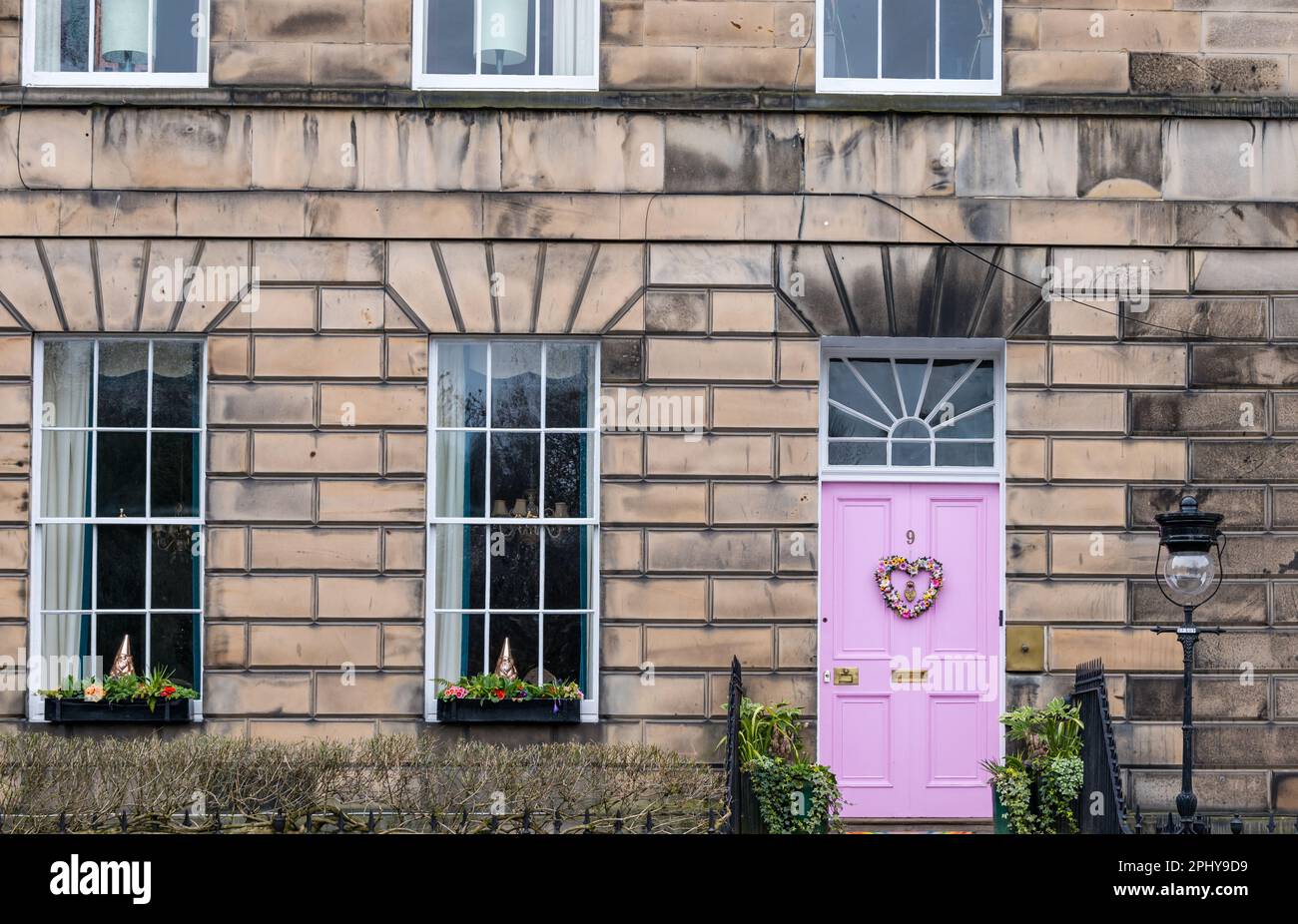 Drummond Place, Edimburgo, Scozia, Regno Unito, 30th marzo 2023. Decorazione della corona di Pasqua: La controversa porta rosa della Città Nuova è decorata per Pasqua. Il proprietario, Miranda Dickson, è stato detto dal consiglio comunale di Edimburgo che deve cambiare il colore nel sito patrimonio dell'umanità dell'UNESCO entro aprile o rischiare una multa, dopo aver perso un appello al governo scozzese. Credit: Sally Anderson/Alamy Live News Foto Stock