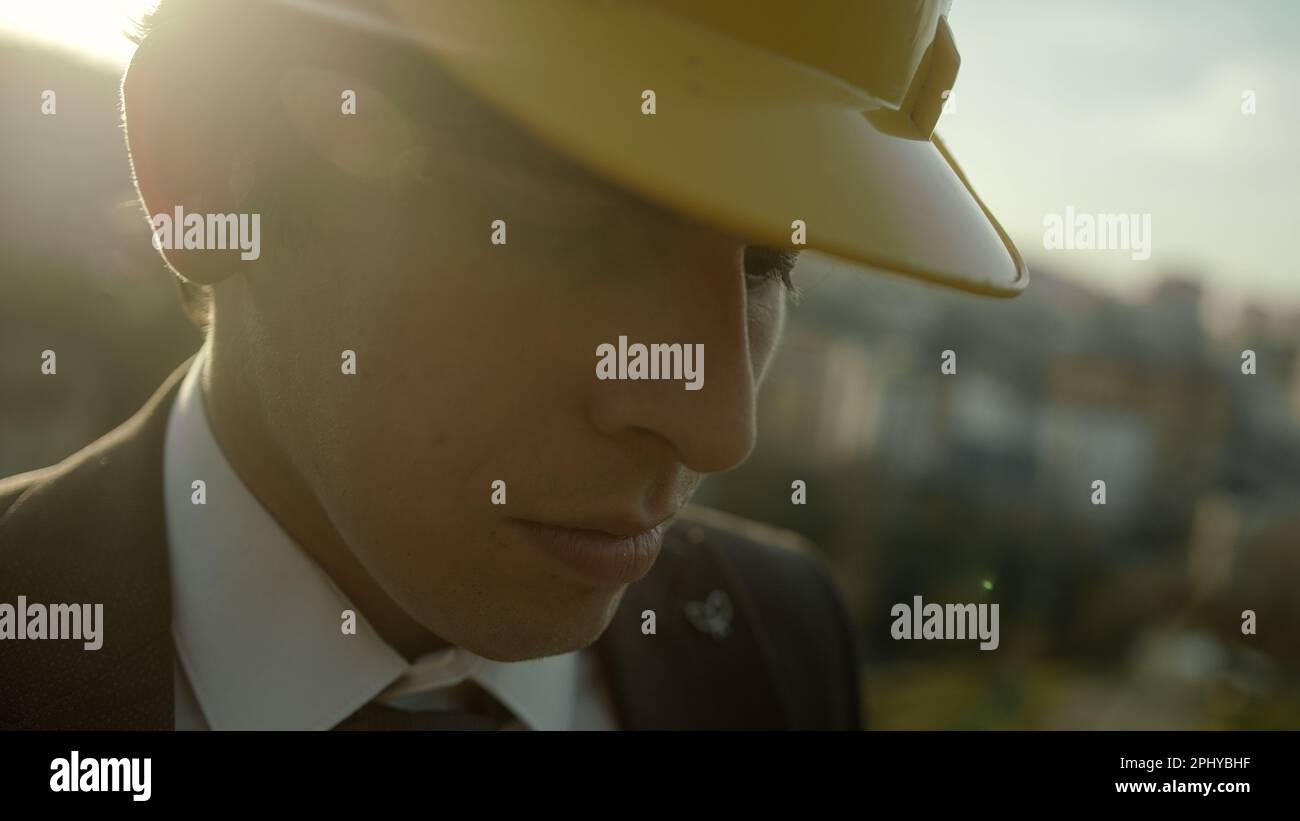 Sguardo profondo e significativo di un giovane uomo d'affari o ingegnere vestito, senza orecchio e beretto Foto Stock