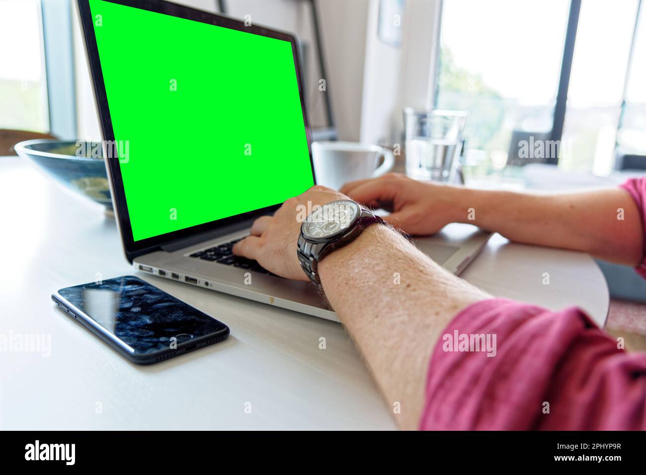 Giovane uomo professionista che utilizza un computer portatile con schermo verde - indossando un orologio di moda. Lavoro da casa - Londra, Regno Unito, 1st giugno 2019 Foto Stock