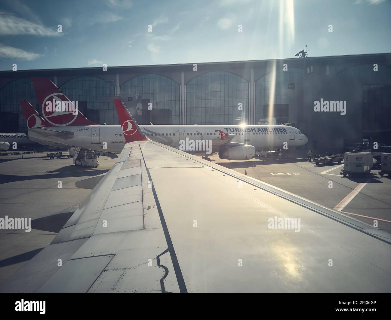 Ala dell'aereo Turkish Airlines, aerei sul campo aereo e edificio del terminal dell'aeroporto di Istanbul Great. Vista dal porthole. Istanbul, Turchia - Febbraio 2023 Foto Stock