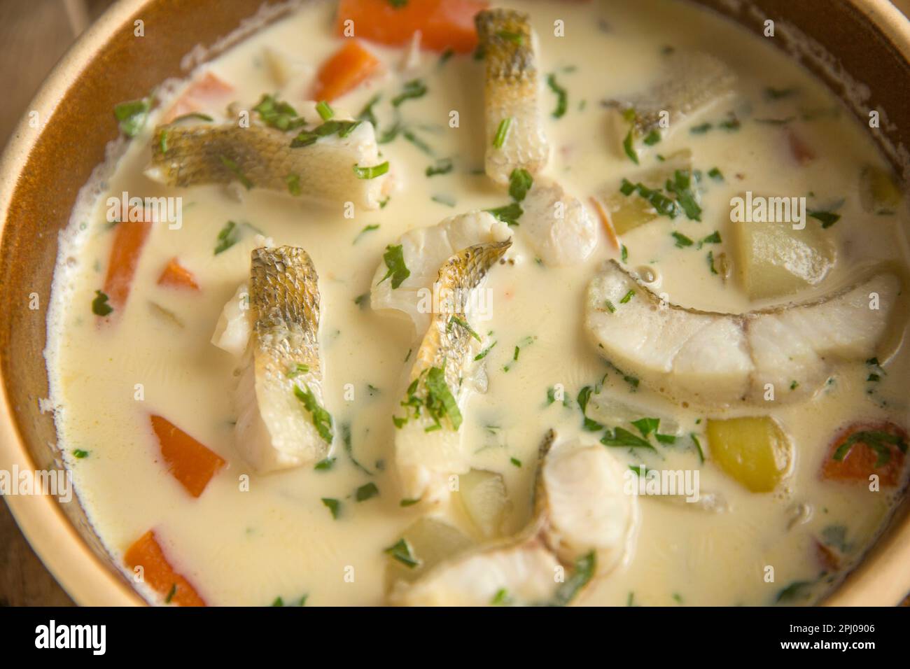 Una zuppa di pesce che include patate, carote e panna con fette di filetto di zander sulla parte superiore. Zander fu introdotto nel Regno Unito nel 19th centu Foto Stock