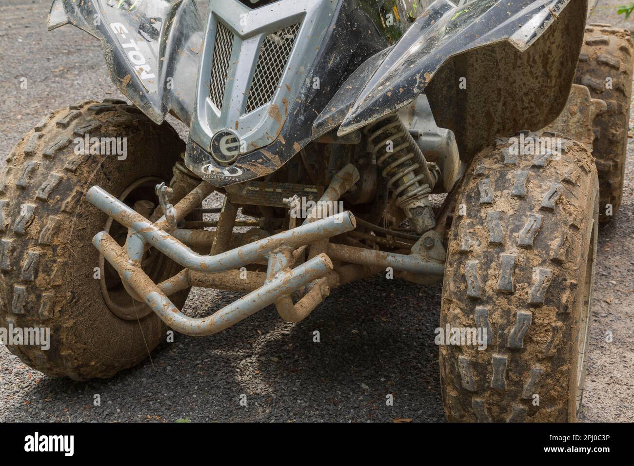 Pneumatici anteriori neri in gomma ricoperti di fango secco su veicoli All Terrain parcheggiati su ghiaia, Quebec, Canada Foto Stock