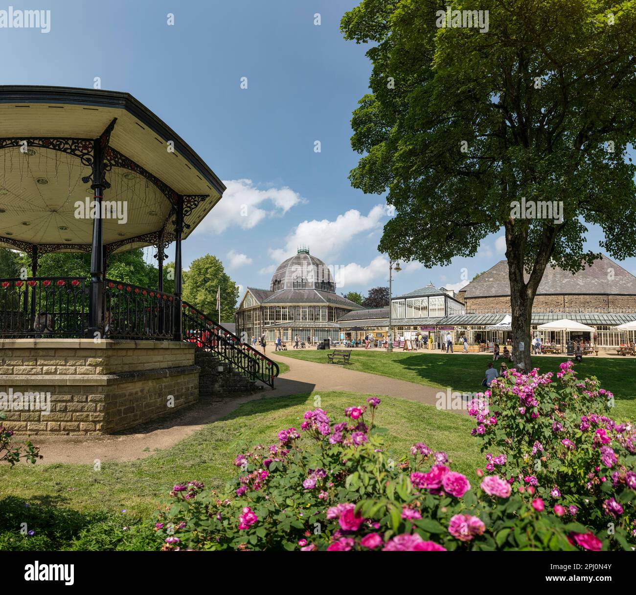 Il palco, ottagono e gli edifici dei Pavilion Gardens nella città termale di Buxton, Derbyshire. Una giornata estiva con rose in un parco pubblico vittoriano Foto Stock