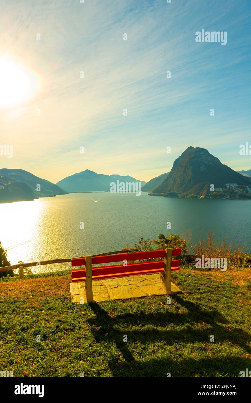 Panchina sul Lago di Lugano e Città con montagna e cielo blu nel Parco San Michele a Castagnola a Lugano, Ticino in Svizzera. Foto Stock Panchina sul Lago di Lugano e Città con montagna e cielo blu nel Parco San Michele a Castagnola a Lugano, Ticino in Svizzera. Foto Stock