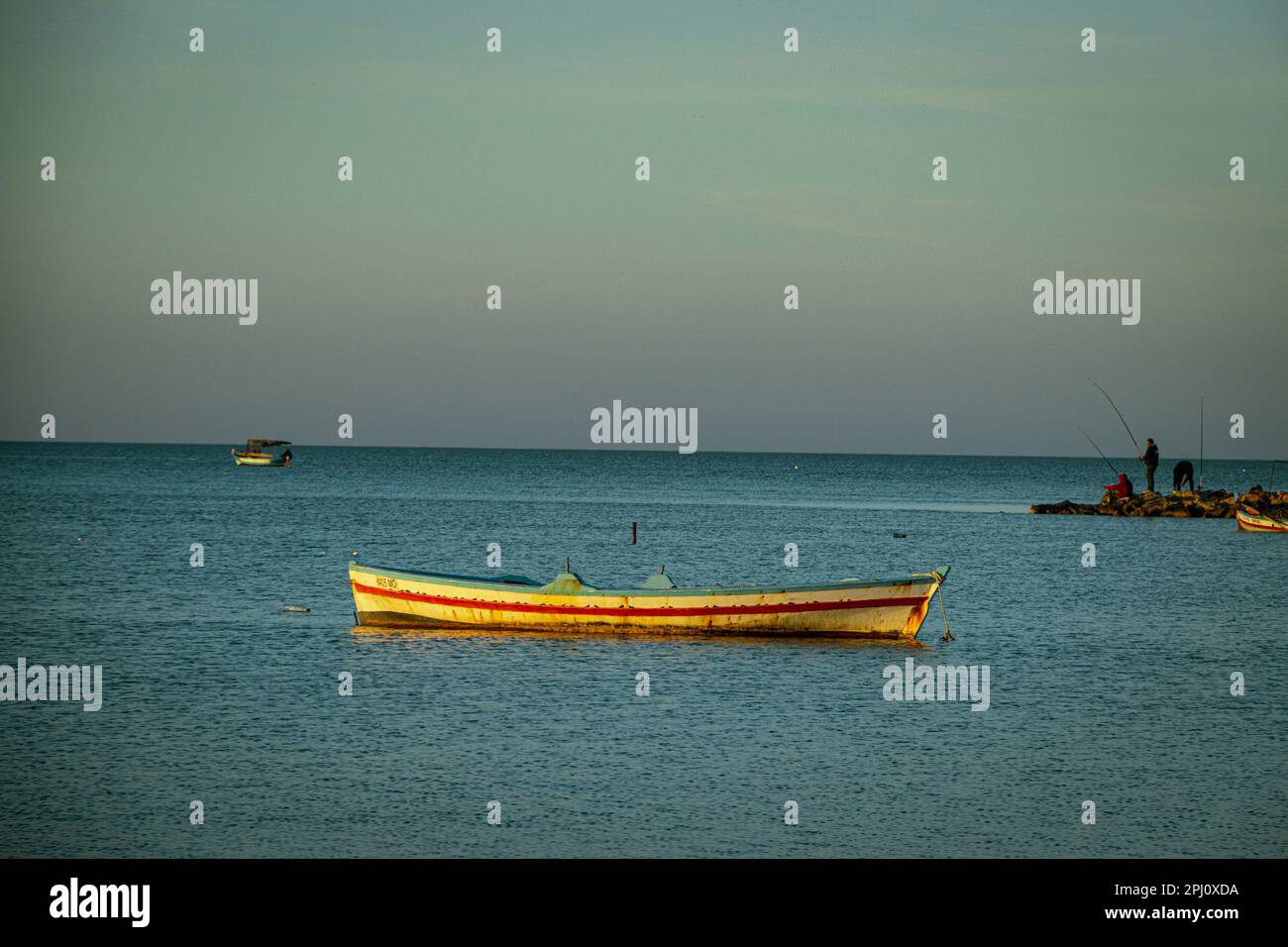 tramonto tunisino sulla costa di monastir con barche e pescatori sullo sfondo Foto Stock