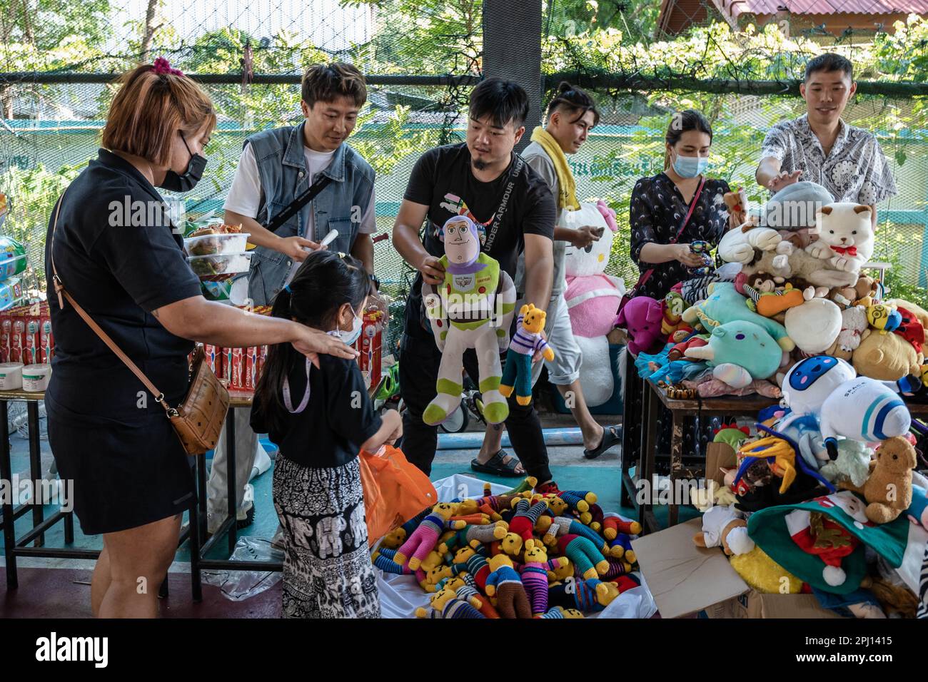 Un team di volontari della Bangkok Community Help Foundation ha visto mostrare giocattoli di seconda mano gratuiti a una madre e a una figlia durante l'evento di beneficenza "Children's and Elders' Day", a Klong Toey, una baraccopoli di lunga data con un'organizzazione comunitaria ben consolidata. La Giornata dei bambini e degli anziani è stata organizzata dal leader della comunità di Rong Moo e dalla fondazione Bangkok Community Help, nel quartiere di Khlong Toey, la più grande baraccopoli di Bangkok, in Thailandia. Foto Stock