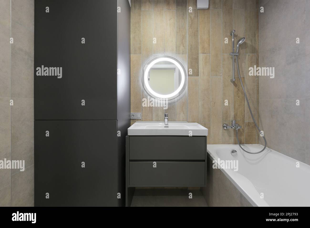 Bagno interno con mobili, lavabo, specchio e vasca bianca Foto Stock