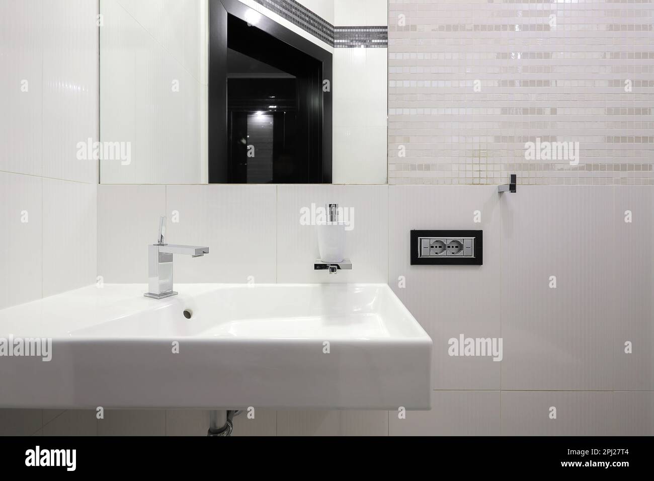 Rubinetto con lavabo in ceramica e specchio all'interno del bagno Foto Stock Rubinetto con lavabo in ceramica e specchio all'interno del bagno Foto Stock