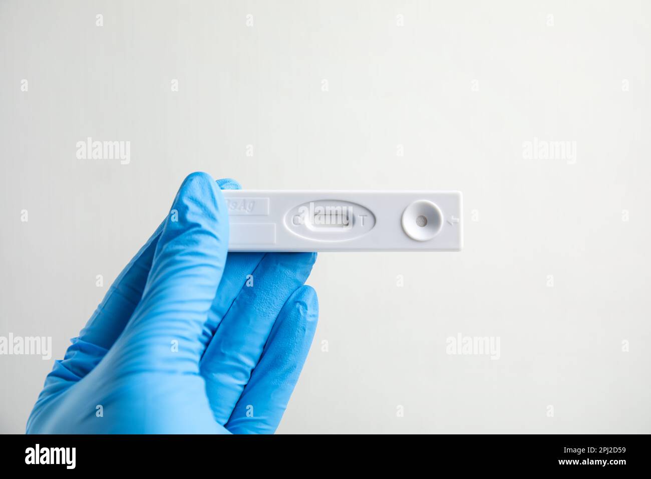 Medico in guanti con test usa e getta express per l'epatite su sfondo bianco, primo piano Foto Stock