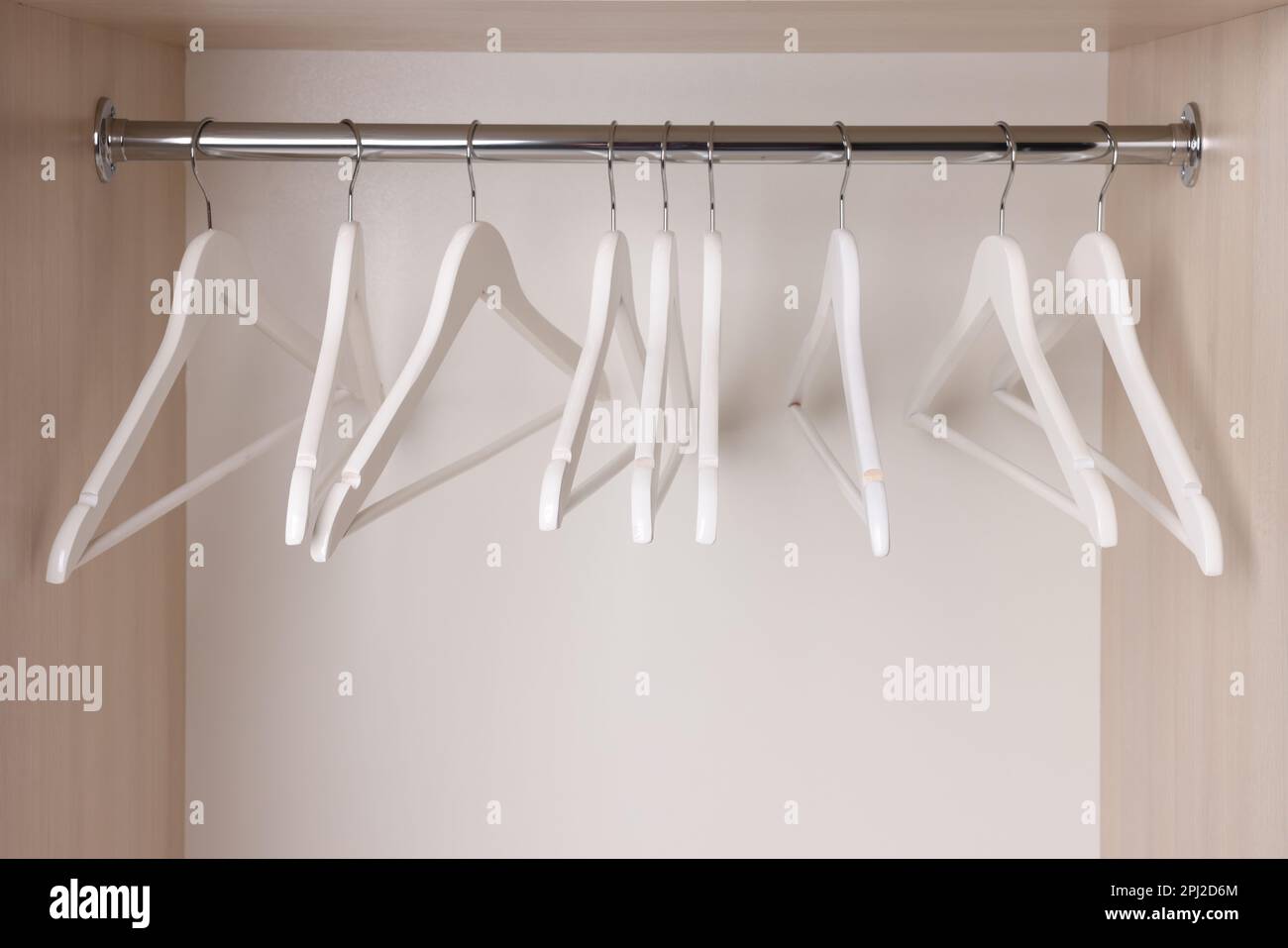 Set di appendiabiti in legno sul corrimano dell'armadio Foto Stock