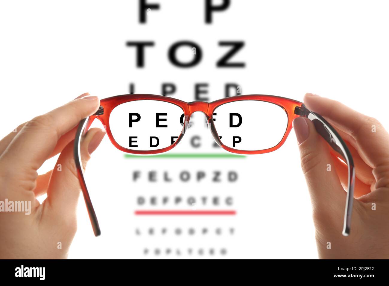 Donna che tiene bicchieri, primo piano. Visualizza attraverso gli obiettivi sulla mappa degli occhi, sfondo bianco Foto Stock