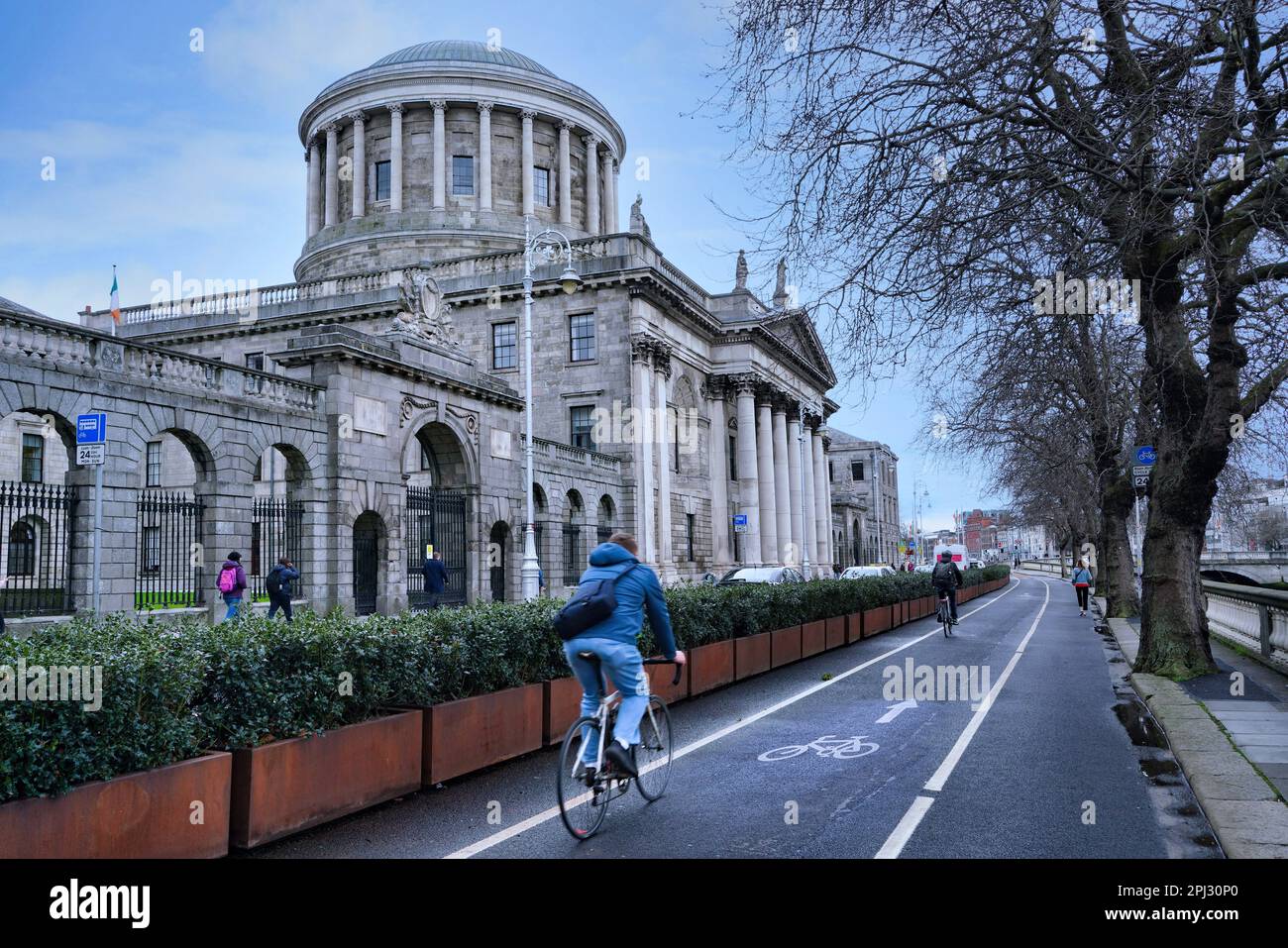 Dublino ha un sacco di ciclisti, che fanno uso di una grande rete di piste ciclabili, come questa accanto al fiume Liffey, di fronte ai quattro campi Foto Stock