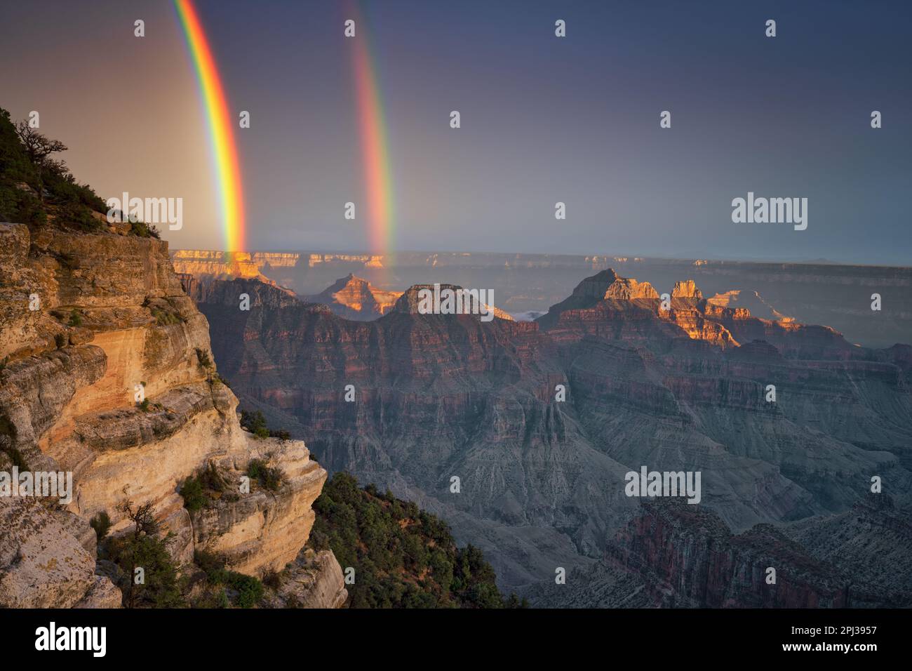 Una breve luce serale durante una tempesta di pioggia estiva crea questo brillante doppio arcobaleno sopra i quattro templi da Bright Angel Point sul Nort Foto Stock