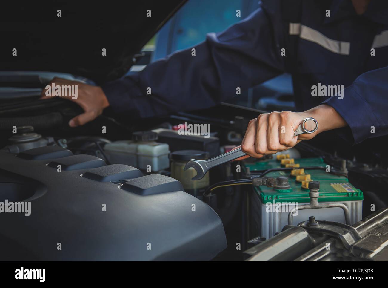 Il meccanico lavora sul motore della vettura in garage, servizio di riparazione auto. Foto Stock