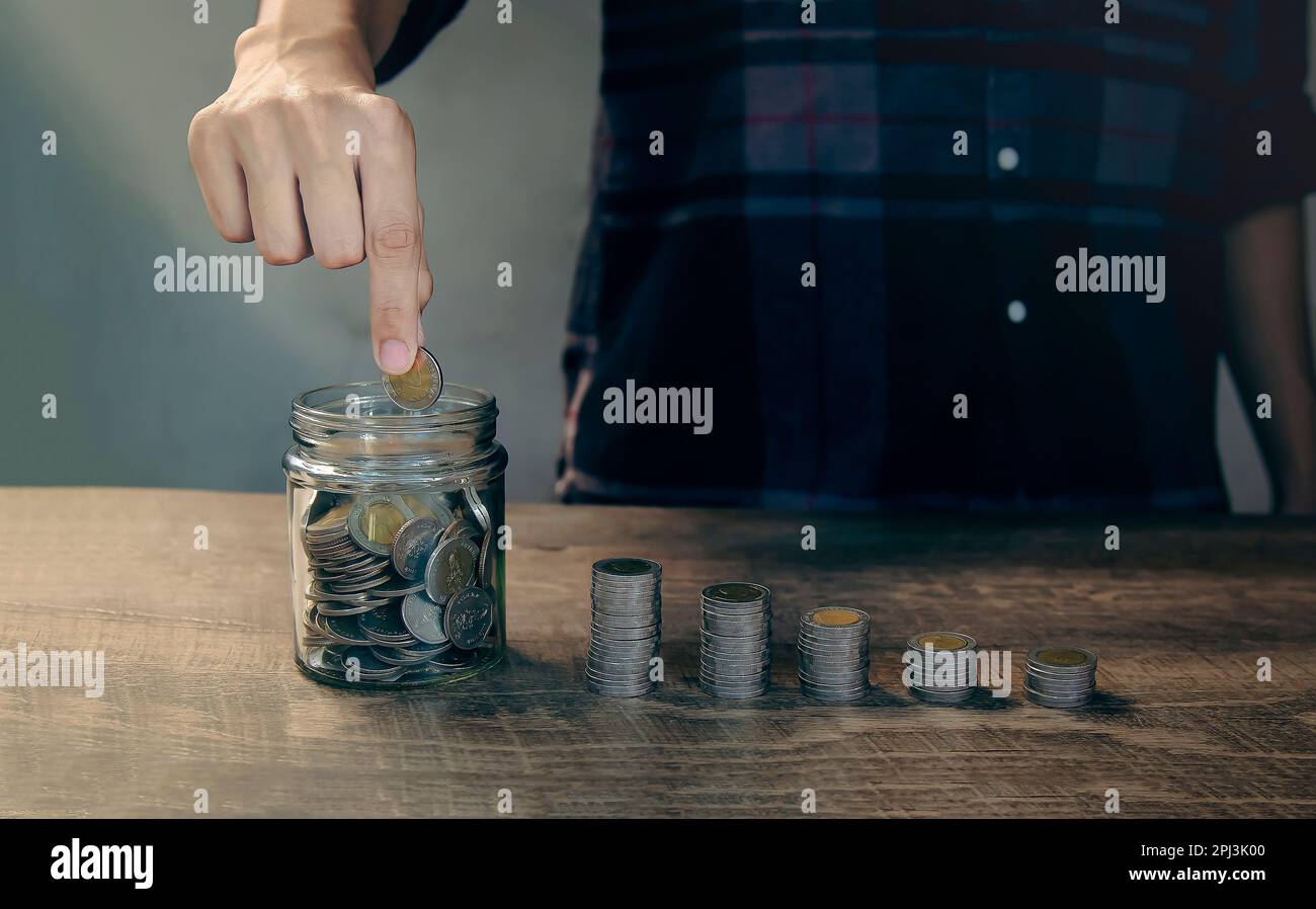 Risparmio e investimenti finanziari mettere monete nel vaso di denaro per risparmiare denaro. Foto Stock