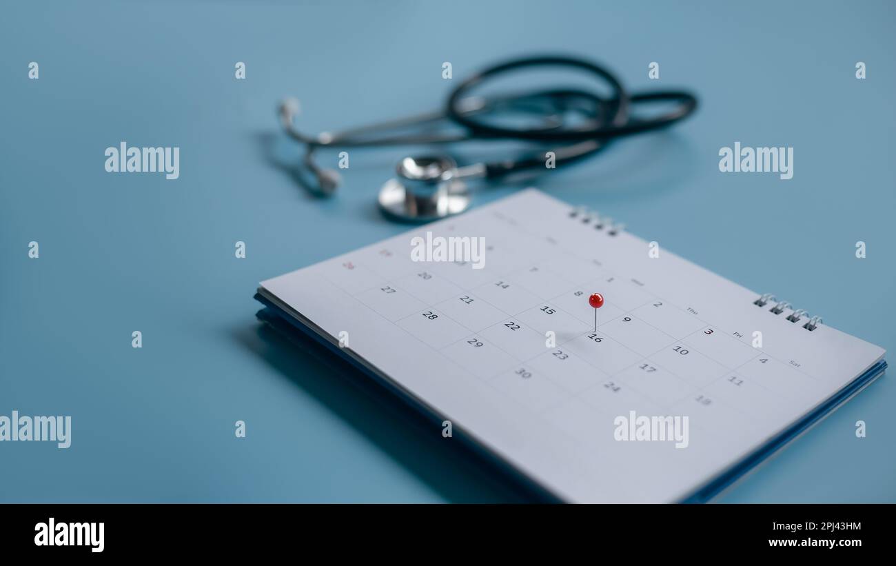 Stetoscopio nero, calendario su sfondo blu, concetto di assistenza sanitaria Foto Stock Stetoscopio nero, calendario su sfondo blu, concetto di assistenza sanitaria Foto Stock