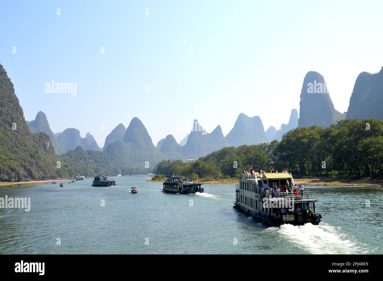Repubblica popolare Cinese, Provincia di Guangxi, Guilin: Il fiume Lijiang, o li, con il suo notevole paesaggio di colline carsiche ricoperte di alberi e una linea Foto Stock