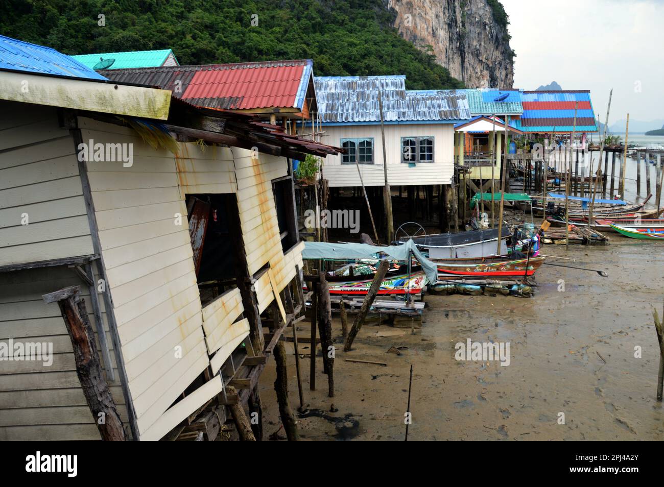 Thailandia, Ao Phang-nga Marine National Park: Ko Panyi Muslim Stilt Village con file di barche ormeggiate, sostenuto da ripide scogliere carsiche. Foto Stock