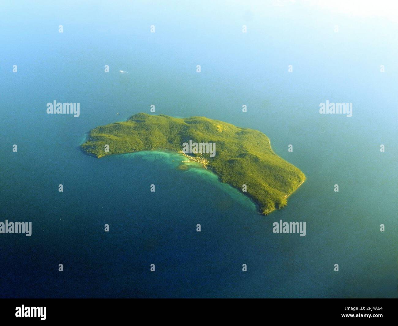 Arcipelago filippino: Vista aerea di una piccola isola boscosa con insediamento costiero. Foto Stock