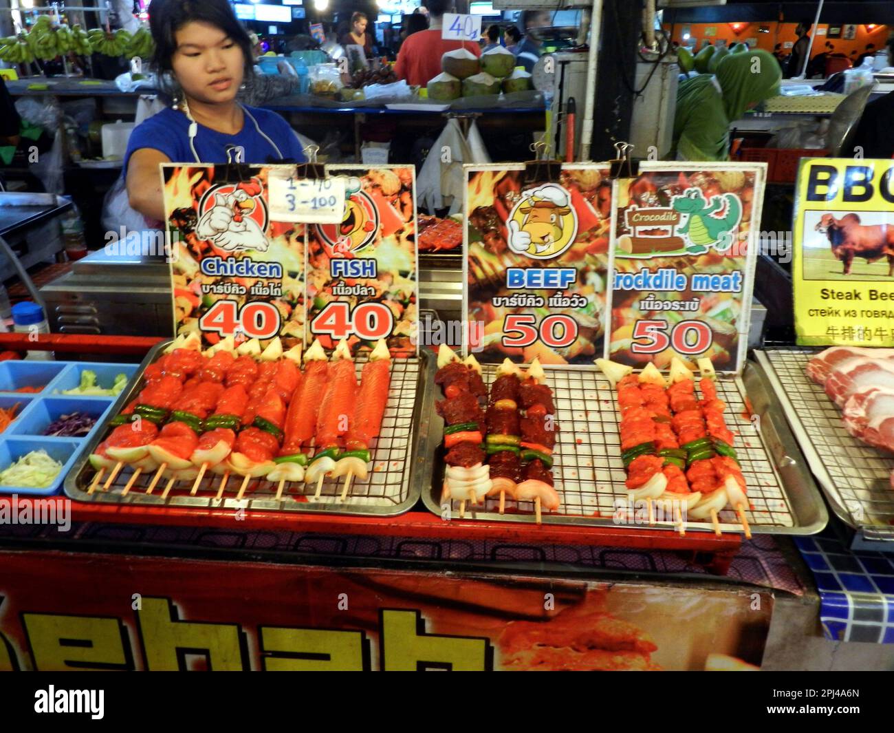Thailandia, Isola di Phuket, Spiaggia di Patong: Il mercato notturno offre una vasta gamma di cibo e spuntini, tra cui pollo, pesce, manzo e carne di coccodrillo Foto Stock