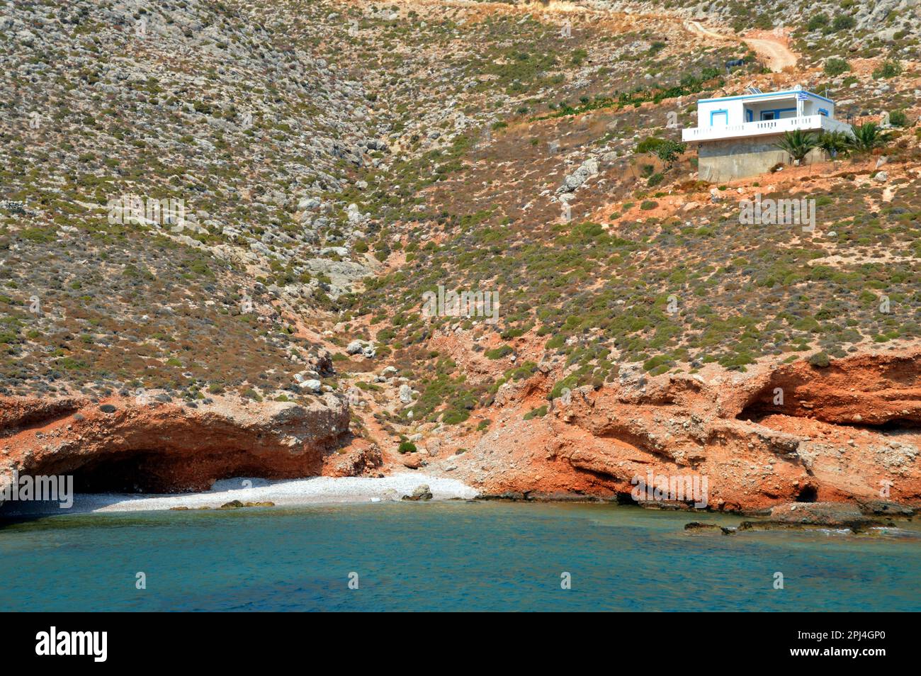 Grecia, Isola di Levitha: Una piccola spiaggia appartata con grotte, senza dubbio utilizzata dai proprietari della casa isolata sopra. Foto Stock