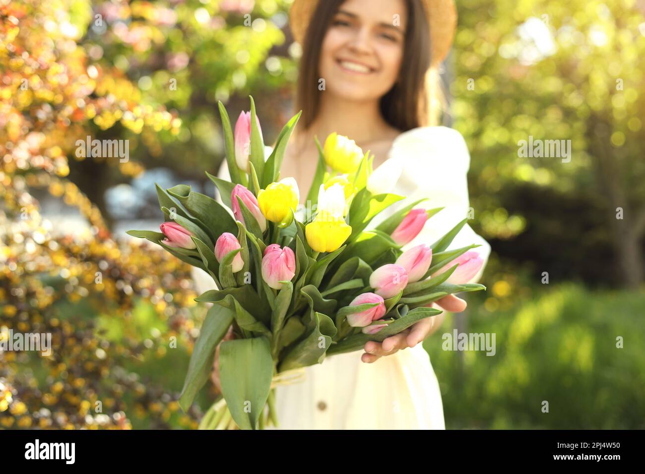 Bella giovane donna con bouquet di tulipani nel parco, focus sui fiori Foto Stock