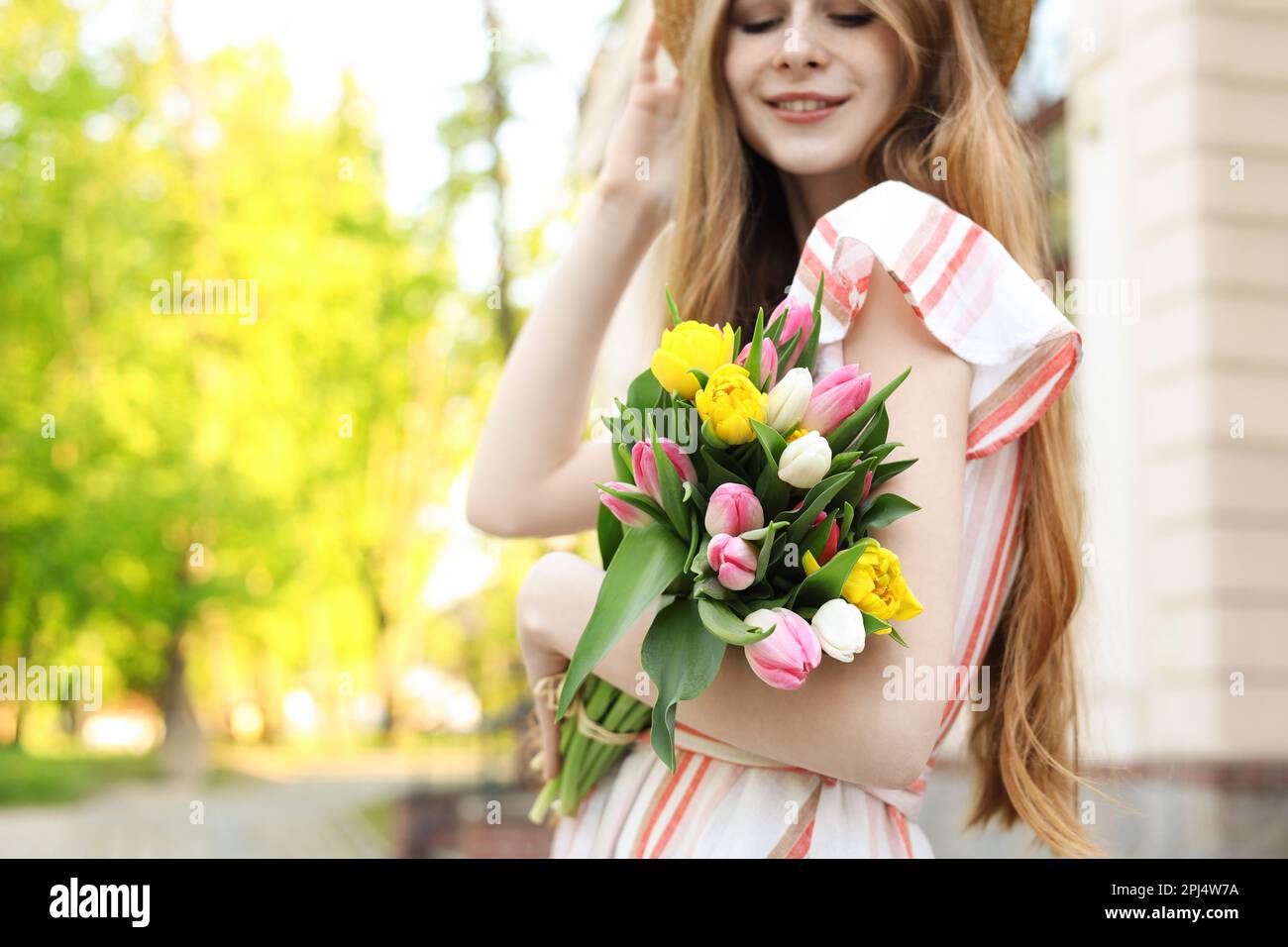 Bella ragazza adolescente con bouquet di tulipani all'aperto, fuoco sui fiori. Spazio per il testo Foto Stock