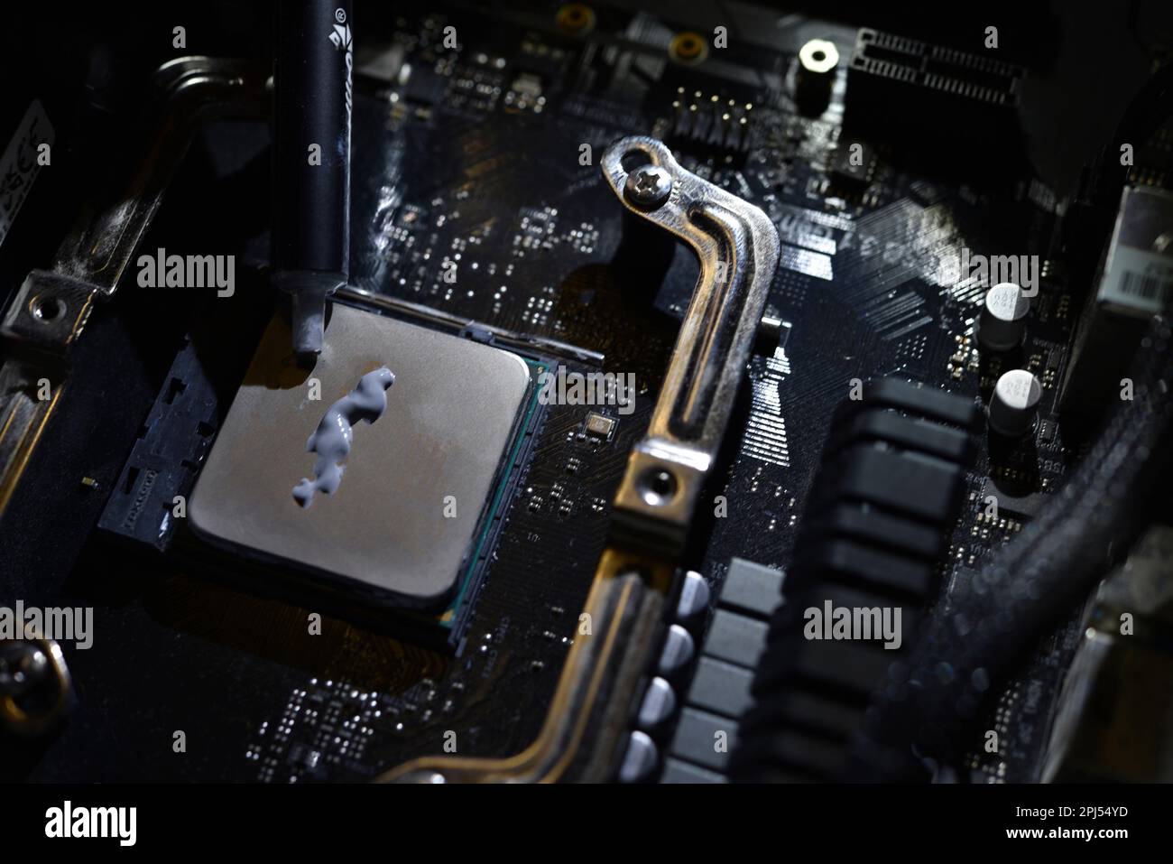 Applicazione di pasta termica sulla superficie del processore del computer. Interfaccia termica sul processore. Foto Stock