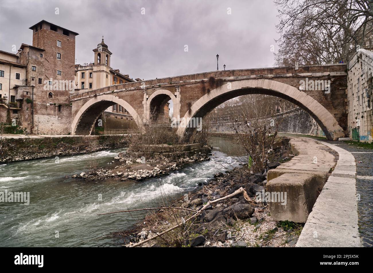 L'isola Tiberina di Roma con rovine di antichi ponti e riflessi sull'acqua Foto Stock