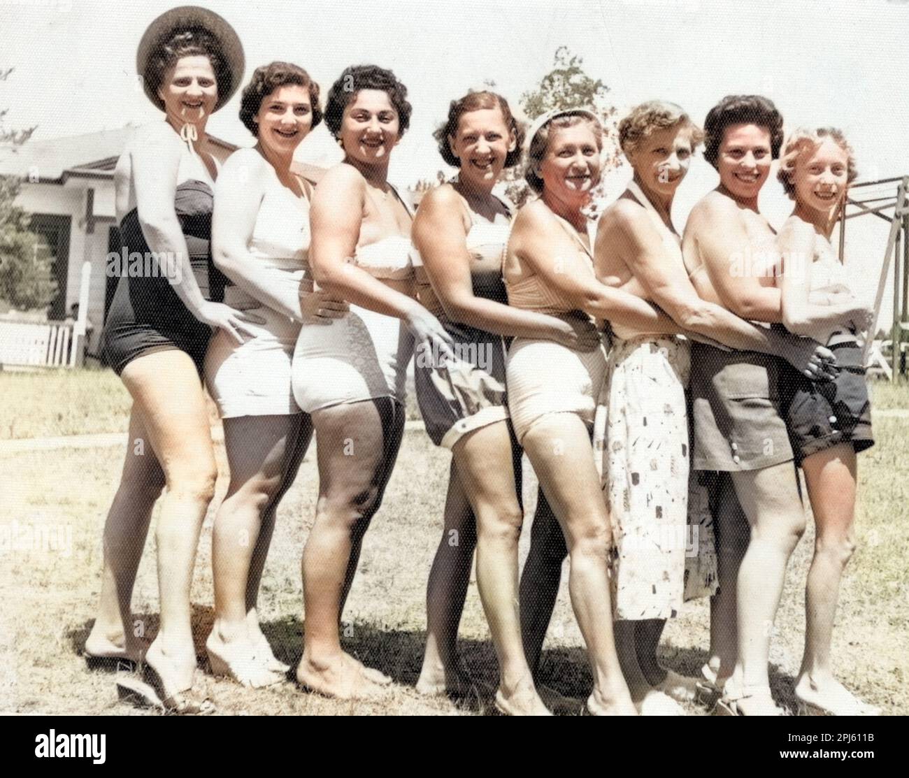Otto bellezze balneari allineate su una spiaggia, circa 1940s. Foto Stock