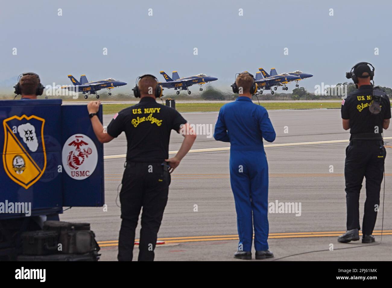 Quattro dei Blue Angels F-18 della Marina degli Stati Uniti d'America decolgono con i membri dell'equipaggio di terra in primo piano. Foto Stock