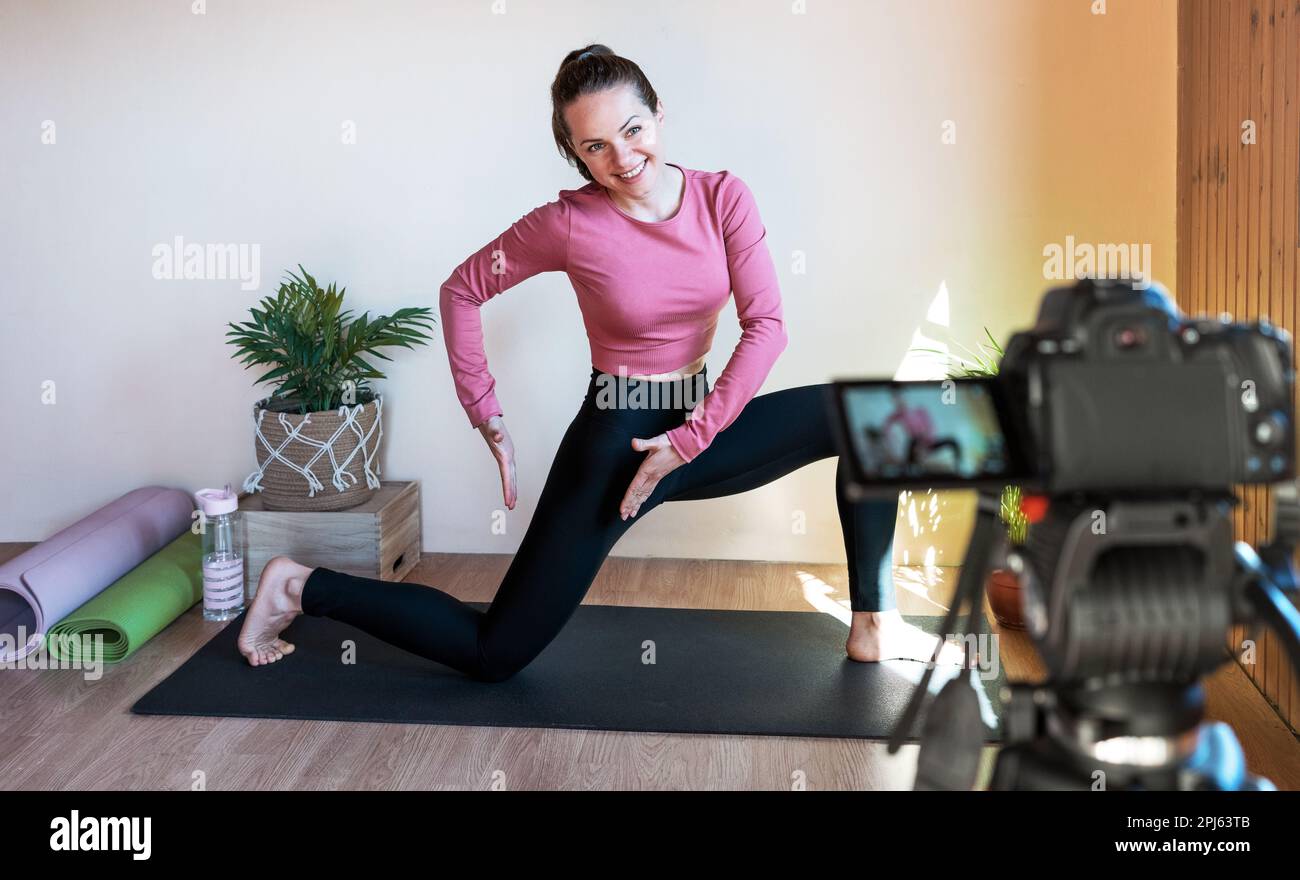 Istruttore di fitness femminile che registra le istruzioni video di allenamento per i suoi iscritti. Foto Stock