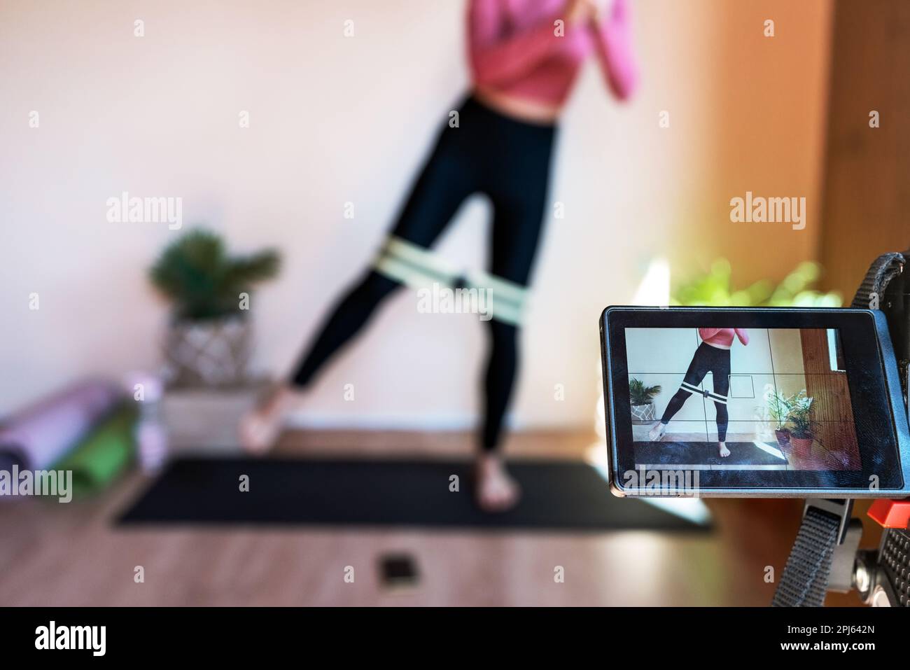 Istruttore di fitness femminile che trasmette in streaming la sua formazione in internet. Foto Stock