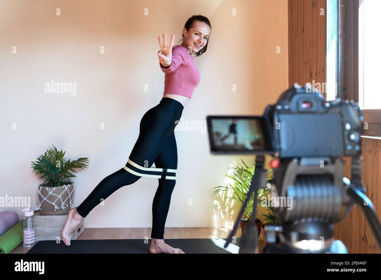 Donna influencer fitness che registra video di allenamento per internet. Foto Stock