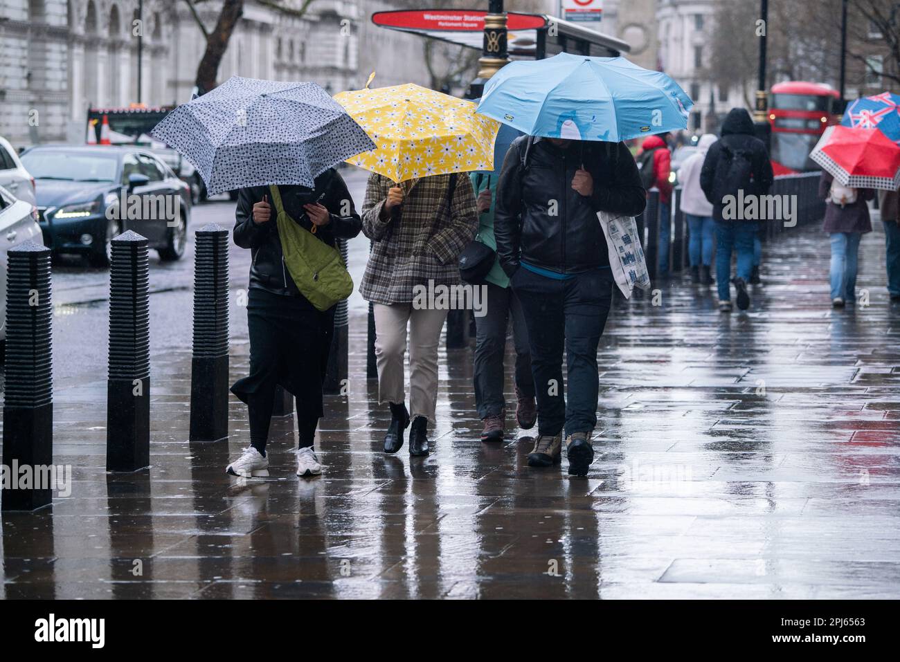 Londra UK 31 marzo 2023.People sheltering con ombrelli come sfidano le condizioni umide e blustery a Westminster. . L'ufficio Met ha emesso un avvertimento giallo di pioggia torrenziale e 70mph venti come Storm Math è quello di colpire parti della Gran Bretagna Credit: amer Ghazzal / Alamy Live. Notizie Foto Stock