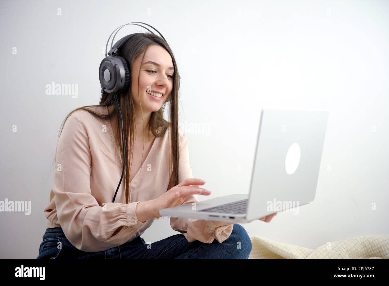 Donna in viaggio d'affari che indossa cuffie bianche per videochiamare al lavoro. Foto di alta qualità Foto Stock
