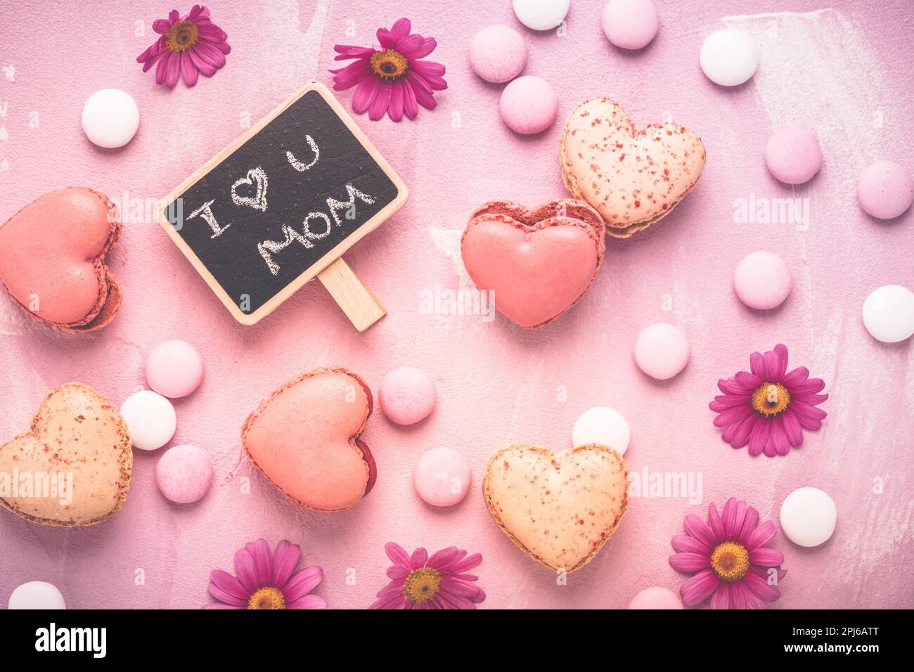 Happy Mothers Day - macaroni dolci a forma di cuore con fiori in tonalità rosa Foto Stock