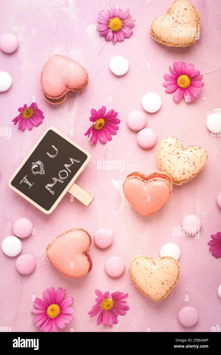 Happy Mothers Day - macaroni dolci a forma di cuore con fiori in tonalità rosa Foto Stock