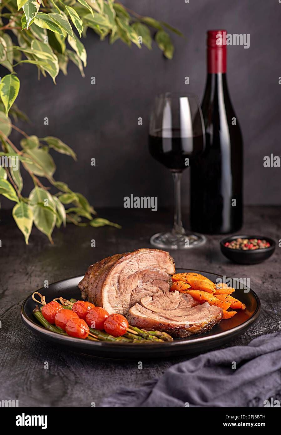 Fotografia alimentare di agnello arrosto, carota, asparagi, pomodoro, vino rosso, bottiglia, wineglass Foto Stock