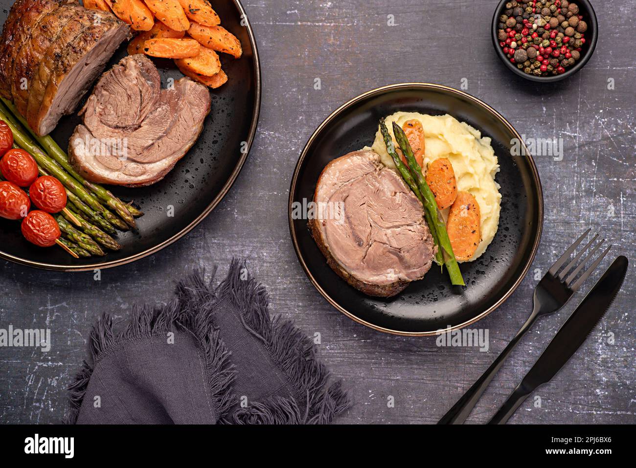 Fotografia alimentare di agnello arrosto, carota, asparagi, pomodoro, condimento, pepe Foto Stock