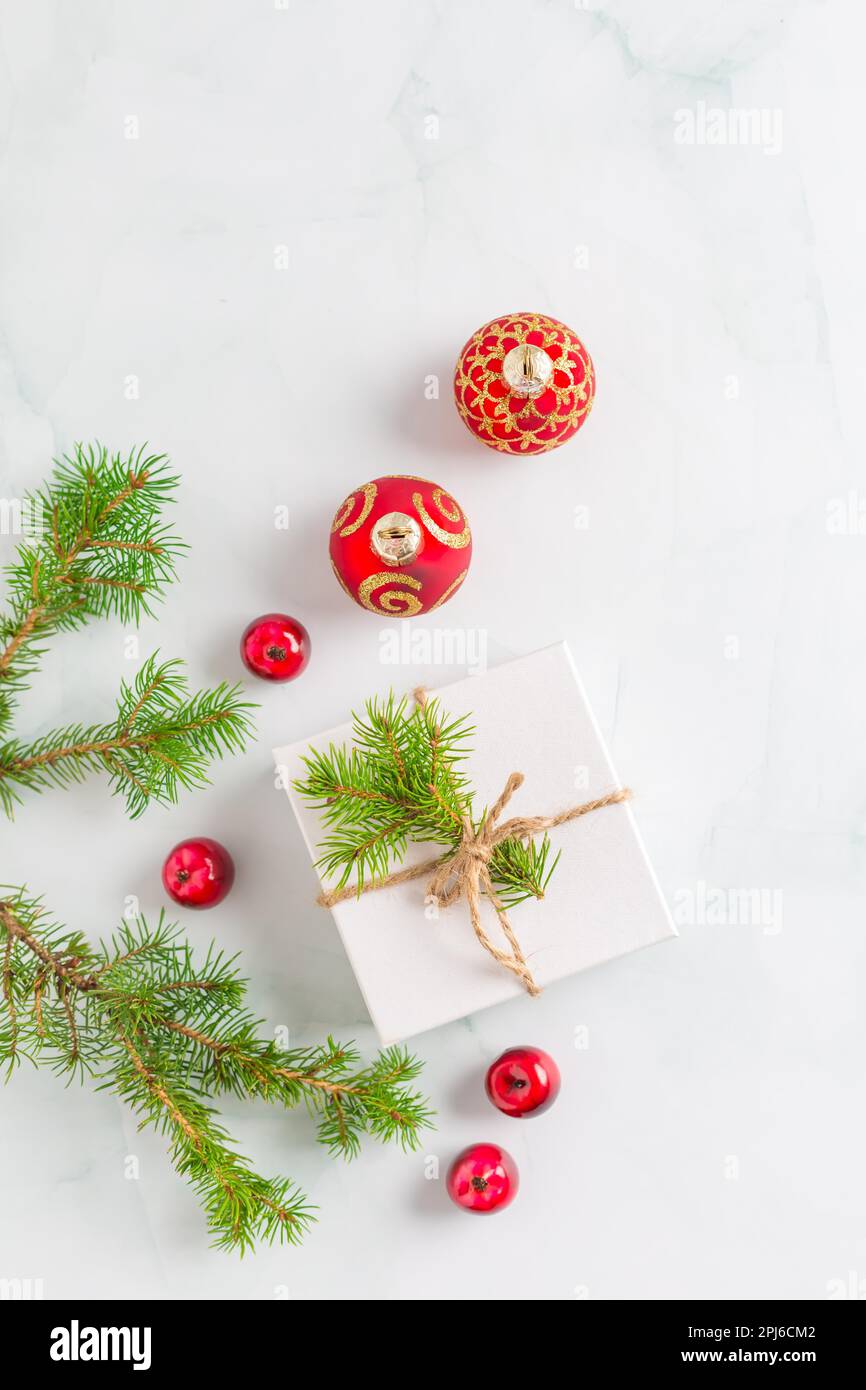 Composizione di Natale. Regalo di Natale, rami di abete su sfondo bianco in legno. Piano di giacitura, vista dall'alto, copyspace Foto Stock