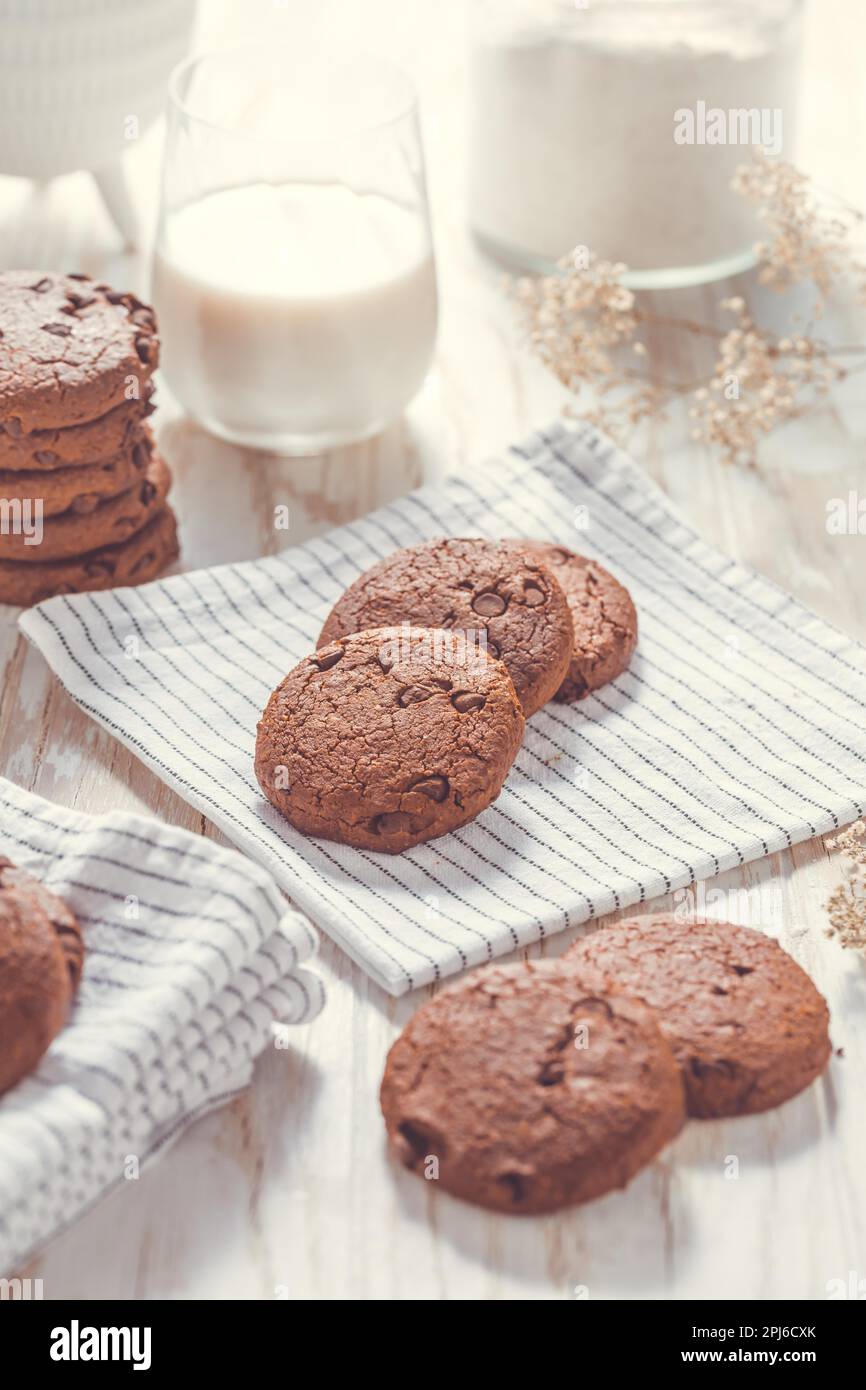 Biscotti al doppio cioccolato con latte sul tavolo da cucina Foto Stock
