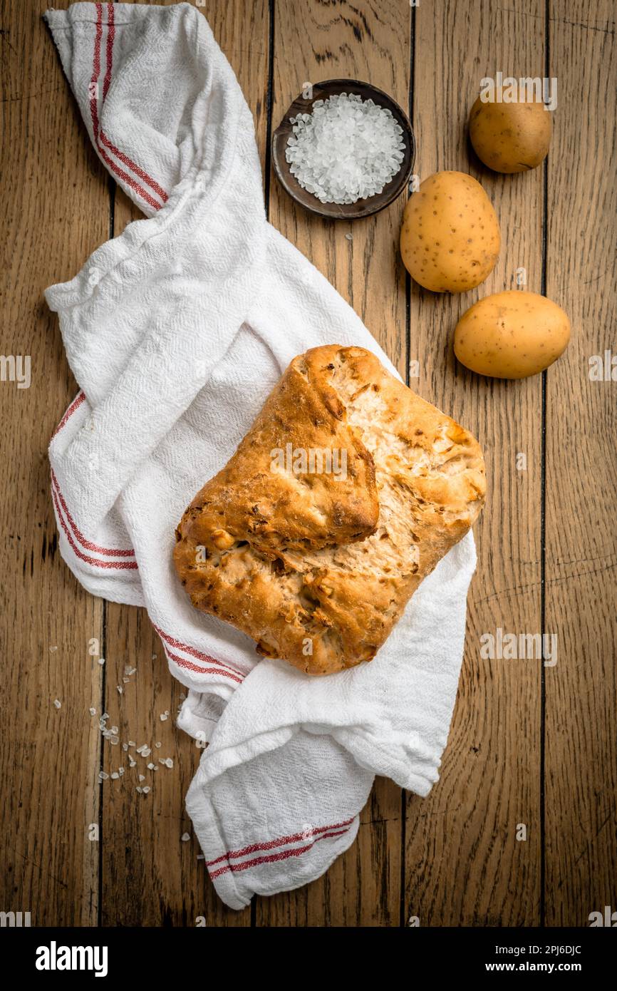 Pane di patate con farina di farro e cipolle tostate su tavola di legno Foto Stock