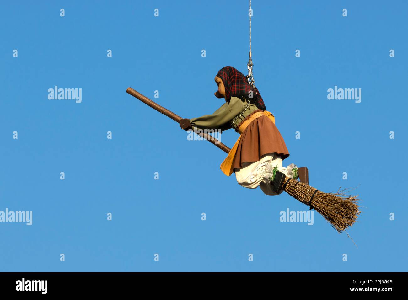 Una bambola di strega su un bastone da scopa è sospesa nell'aria e un cielo blu sullo sfondo, Ehingen, Baden-Wuerttemberg, Germania Foto Stock