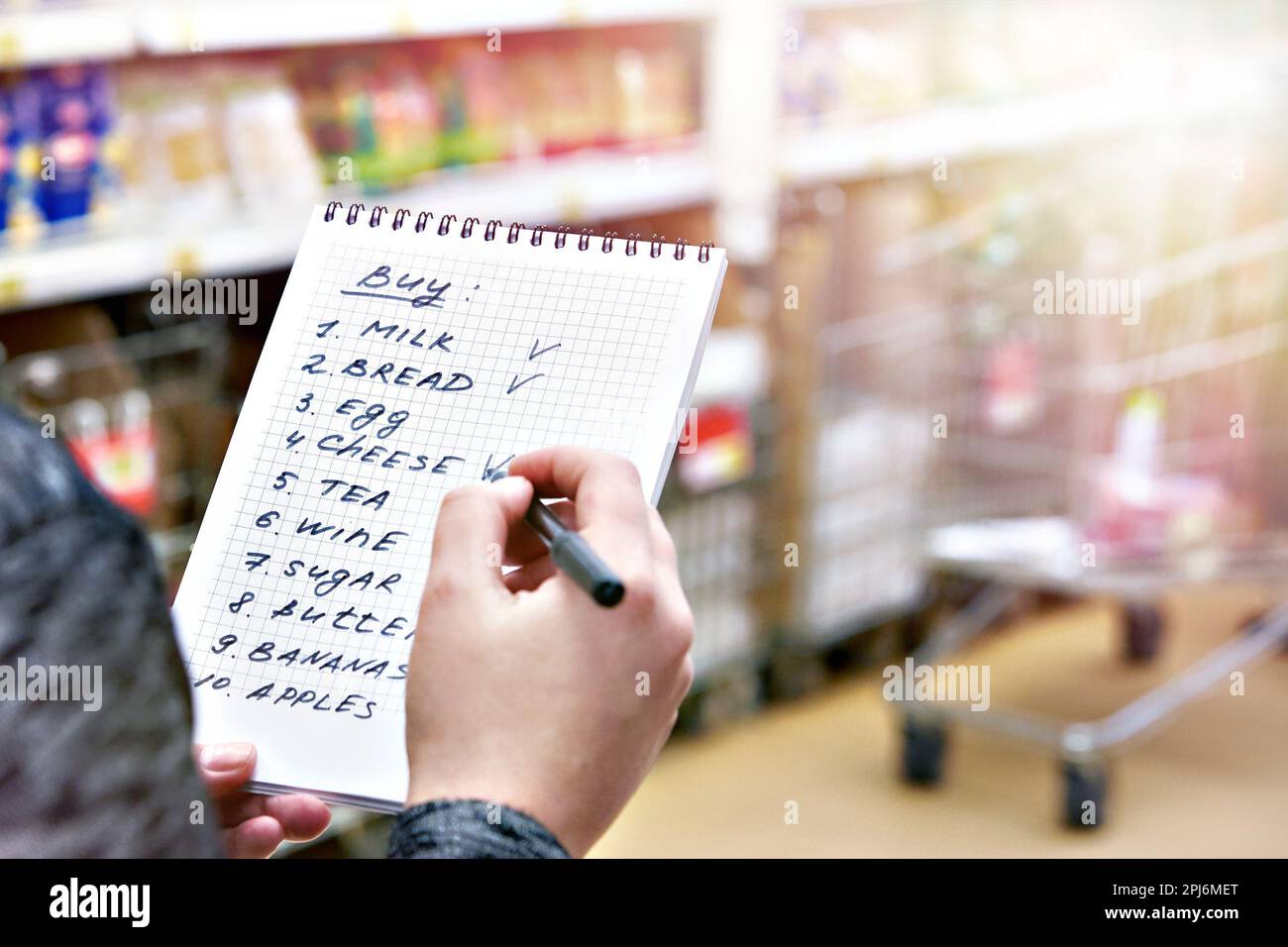 Lista della spesa nelle mani di una donna in un supermercato Foto Stock