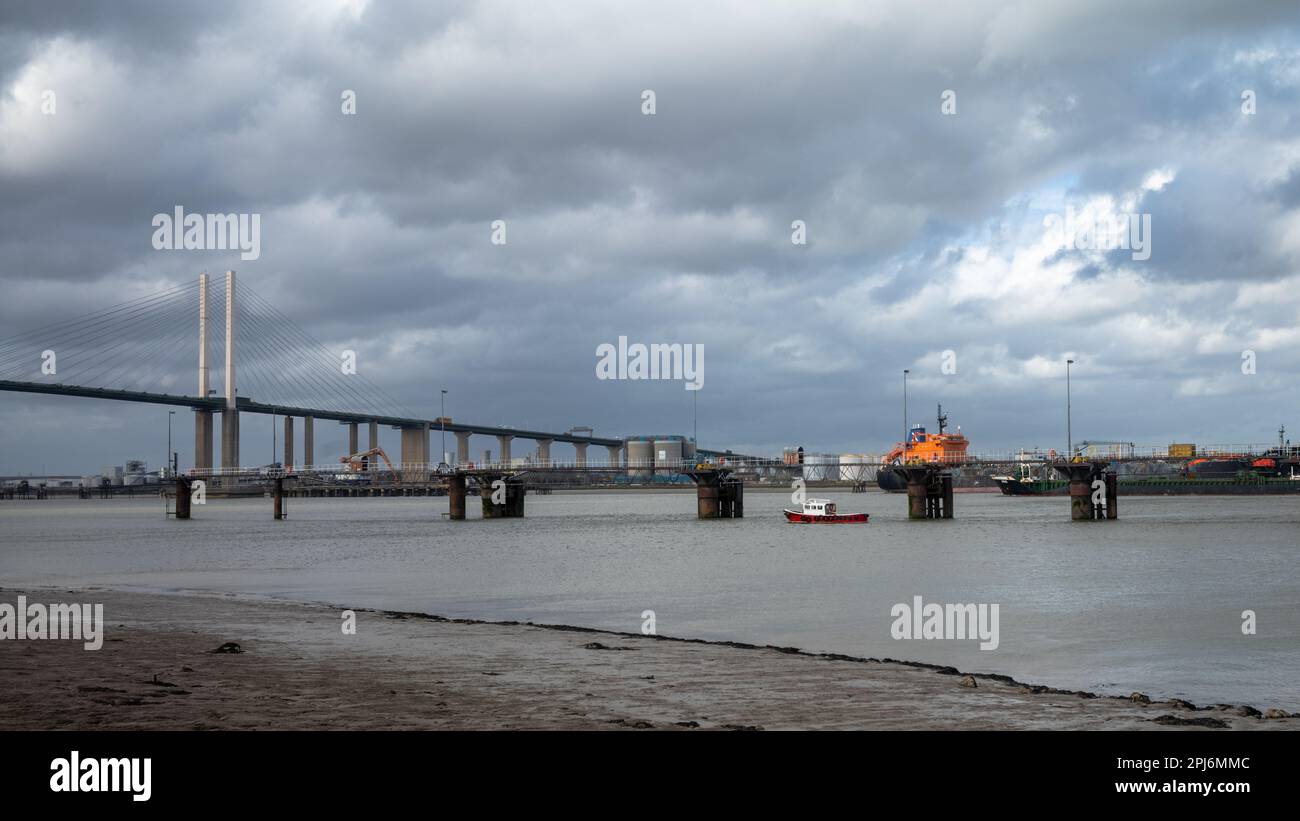 Una piccola barca e altre navi sul Tamigi vicino al Dartford Crossing, o QE2 Bridge vicino a Londra, Regno Unito. Foto Stock